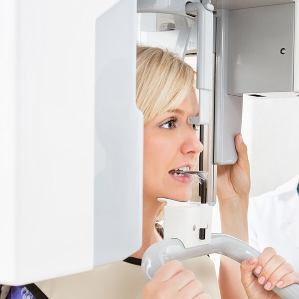 A blonde woman in a CBCT machine