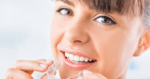 Photo of a woman holding an Invisalign tray